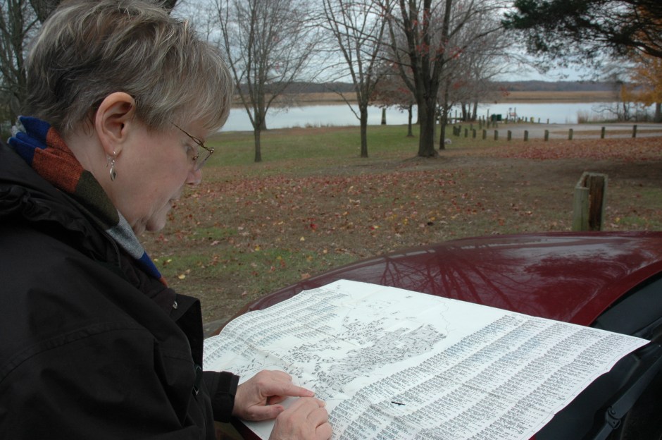 Susan Tichy at Magruder's Ferry, with map of early plantations in Prince George's County. Photo: Margaret Yocom, 2013.